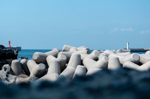 堤防に並ぶテトラポッドと青い空、海岸防災工事の消波ブロック