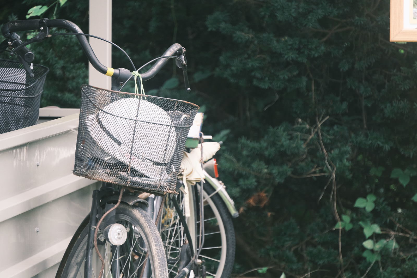 階段の手すりに立て掛けられた自転車の前かごに白いヘルメットが入っている