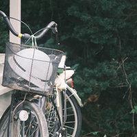 階段の手すりに立て掛けた、ヘルメットがかごに入った自転車の写真