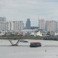 ベトナムのサイゴン川を渡る貨物船と都市風景の写真