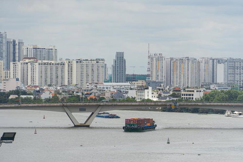 ベトナムのサイゴン川を渡る貨物船と都市風景