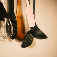 キッチンの壁に吊るしたヘラとお玉の調理器具の写真
