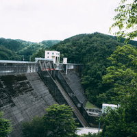 山に佇むコンクリートの壁（羽生ダム）の写真