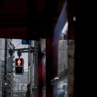 赤く点灯した歩行者信号の止まれ表示と横断歩道の写真