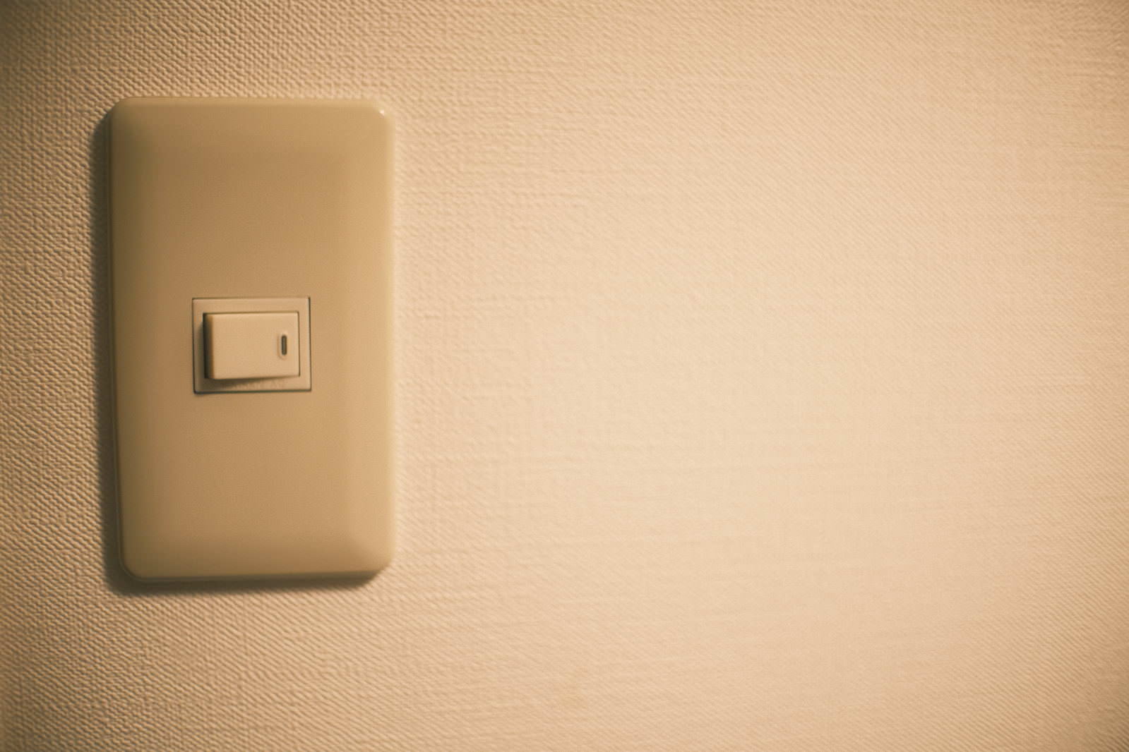 ベージュ色の壁に取り付けられた電気スイッチ