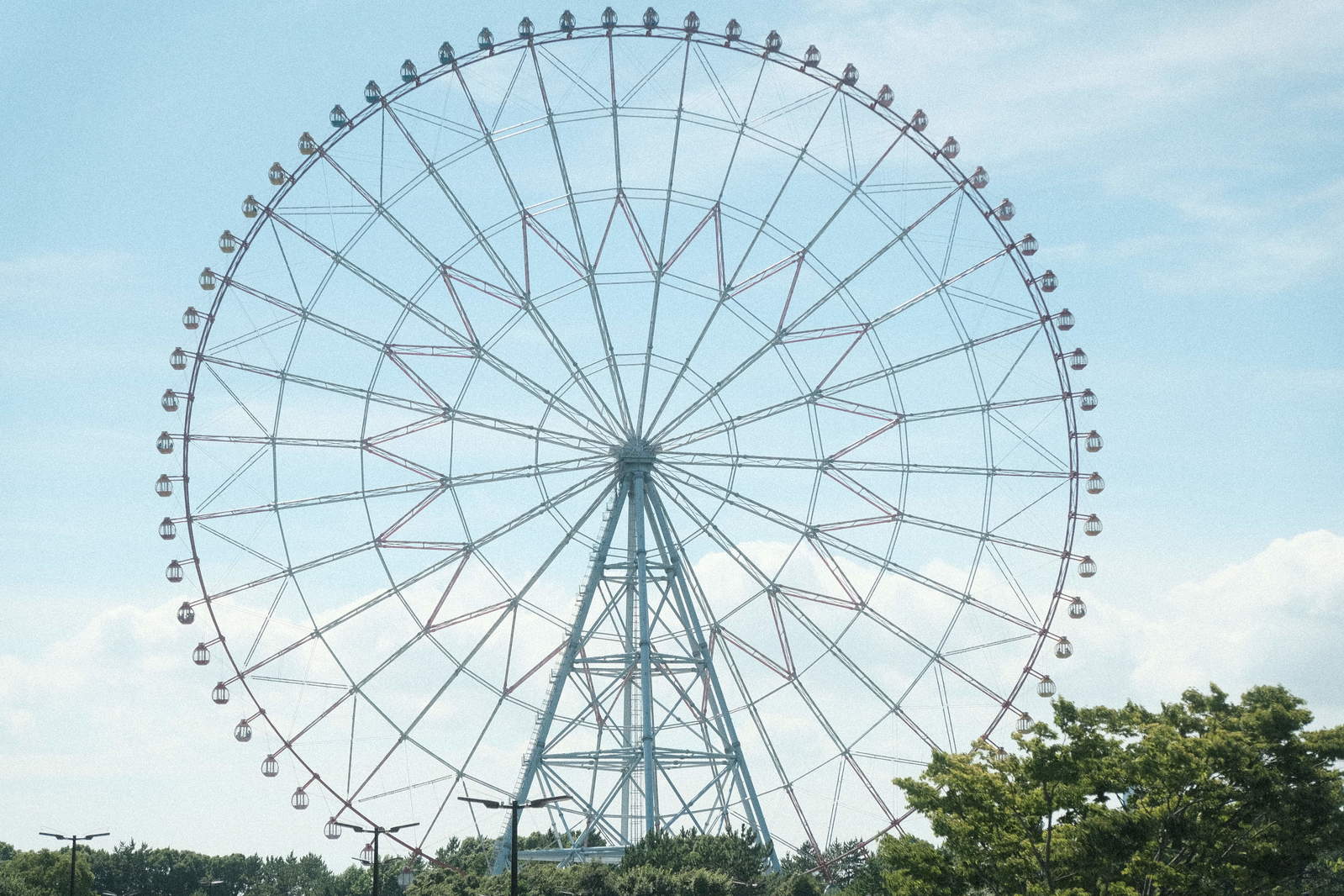 青空を背景にした遊園地の大きな白い観覧車