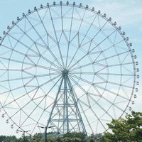 青空と白い雲を背景にした遊園地の大きな観覧車の写真