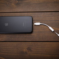 3.5mmヘッドフォン端子が廃止され変換器を使用するiPhoneの写真