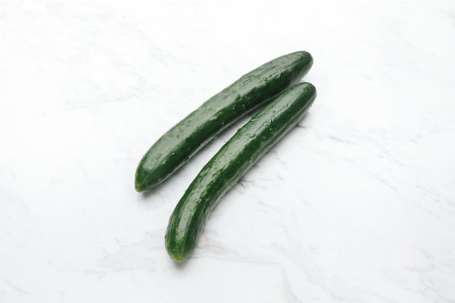 採れたてのきゅうり2本、白い大理石調の背景