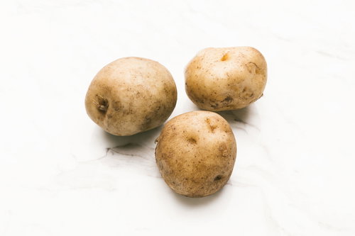 土がついた採れたてのじゃがいも3個