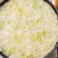 黒いフライパンで野菜を炒めるキャベツとほうれん草のひと煮立ちの写真