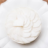 白い皿に盛り付けたかぶの薄切りをケーキに載せた野菜デコレーションの写真