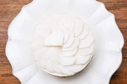白い皿に盛り付けたかぶの薄切りをケーキに載せた野菜デコレーション