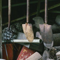 東堂山満福寺の境内に吊られた古い木製ラックのシャベルとスコップの写真