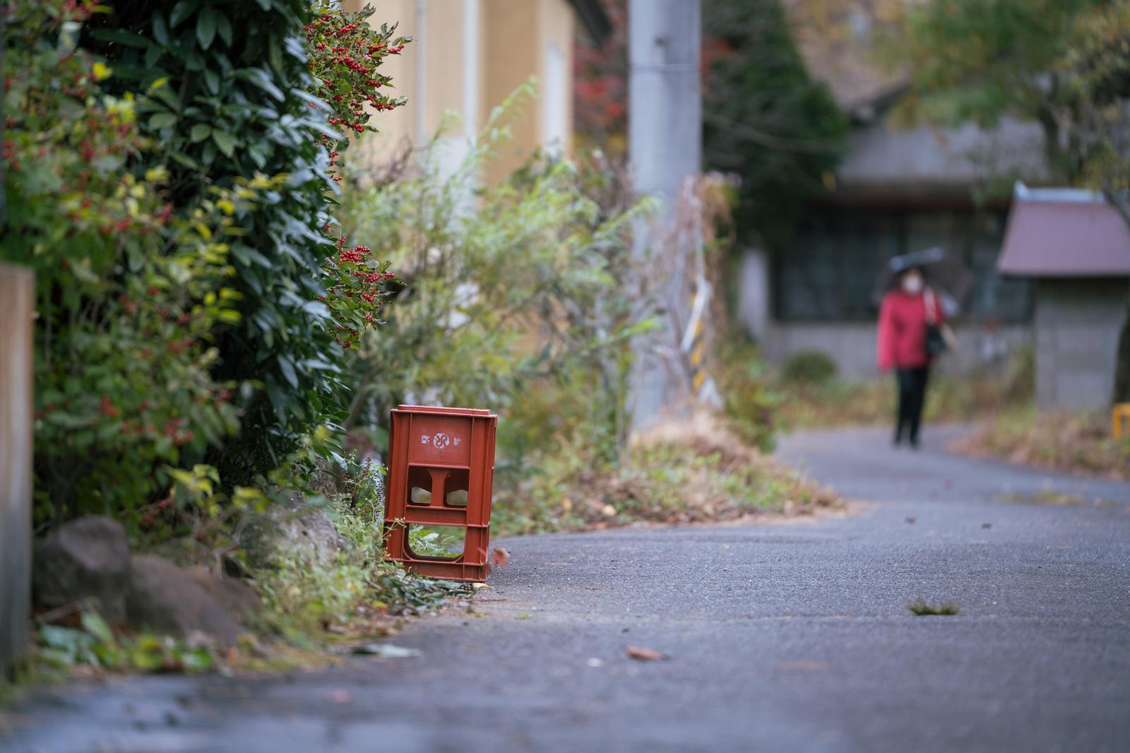 岳温泉の苔むした路地に置かれた赤いビールケースと温泉街の風景