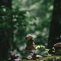 福島県田村市の行司ヶ滝、苔むした岩場に積まれたケルンの写真