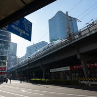有楽町駅前の架線下を走る新幹線とビル群の都市風景の写真