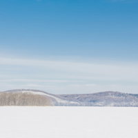 冬の網走湖からの雪景色と山並みを望む北海道の風景の写真