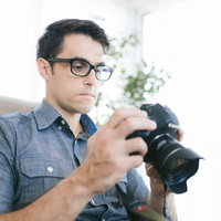 撮影したスチール写真の映像をカメラで確認するイタリア人カメラマンの写真