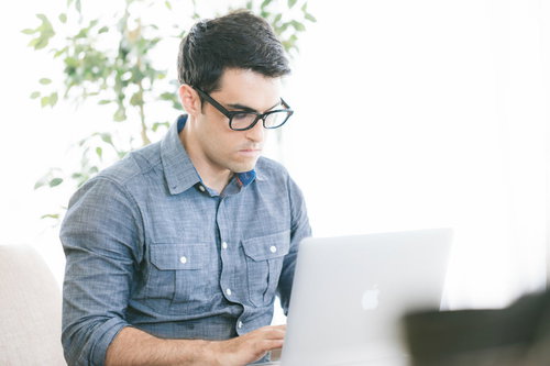 明るいオフィスでコーディング中のエンジニア男性