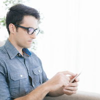 ソファで動作確認中のアプリエンジニア男性の写真
