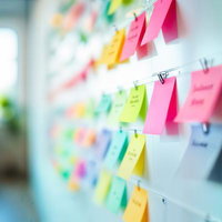 ホワイトボードに貼られたカラフルな付箋の写真