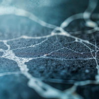 白いひび割れが走る青い石材の表面の写真