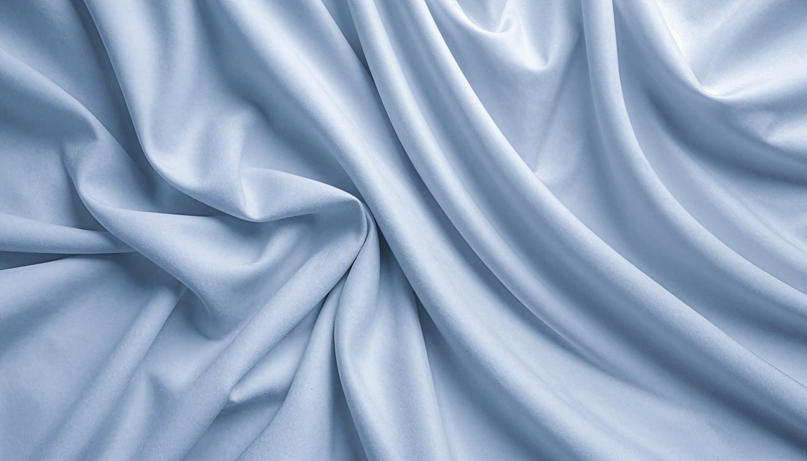 Light blue fabric with soft drapes and folds spreading across