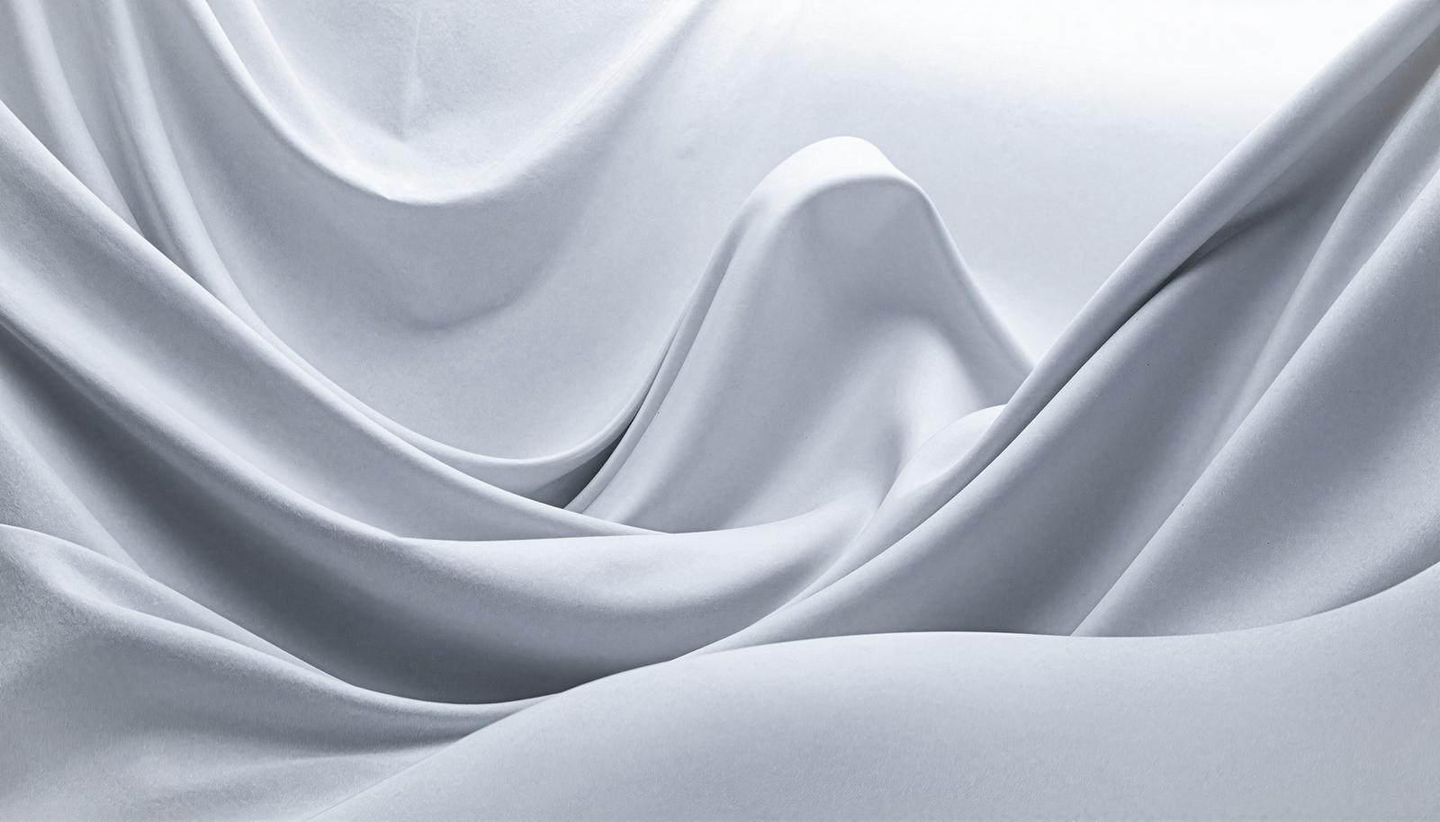 Smooth white silk-like fabric texture with gentle waves