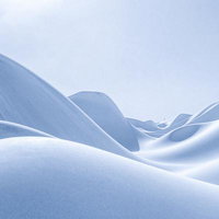 砂丘のような雪の丘が連なる冬の風景の写真