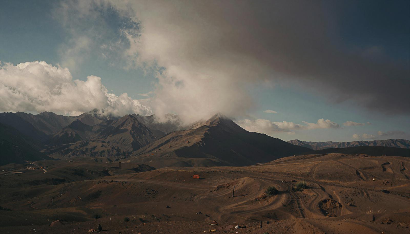 Arid highland landscape with clouds over mountain range