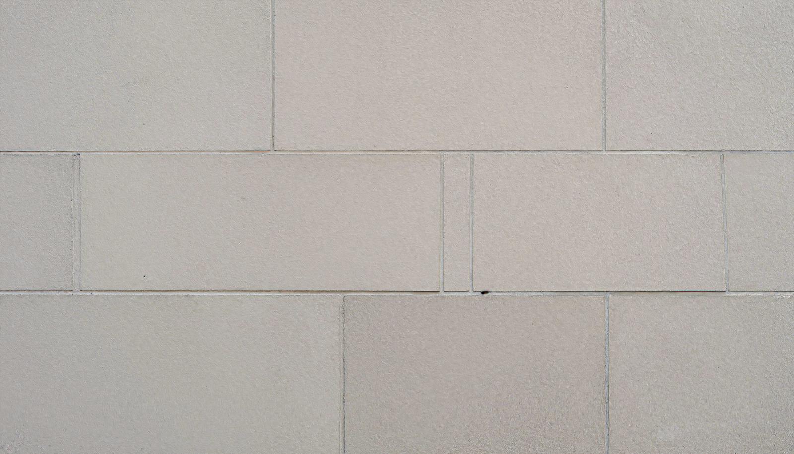 ベージュの長方形タイルが規則的に並ぶ壁面のクローズアップ