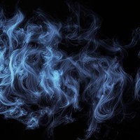 黒背景に映える青色スモークの写真
