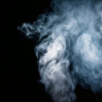 黒背景に立ち上がる白いスモークエフェクトの写真