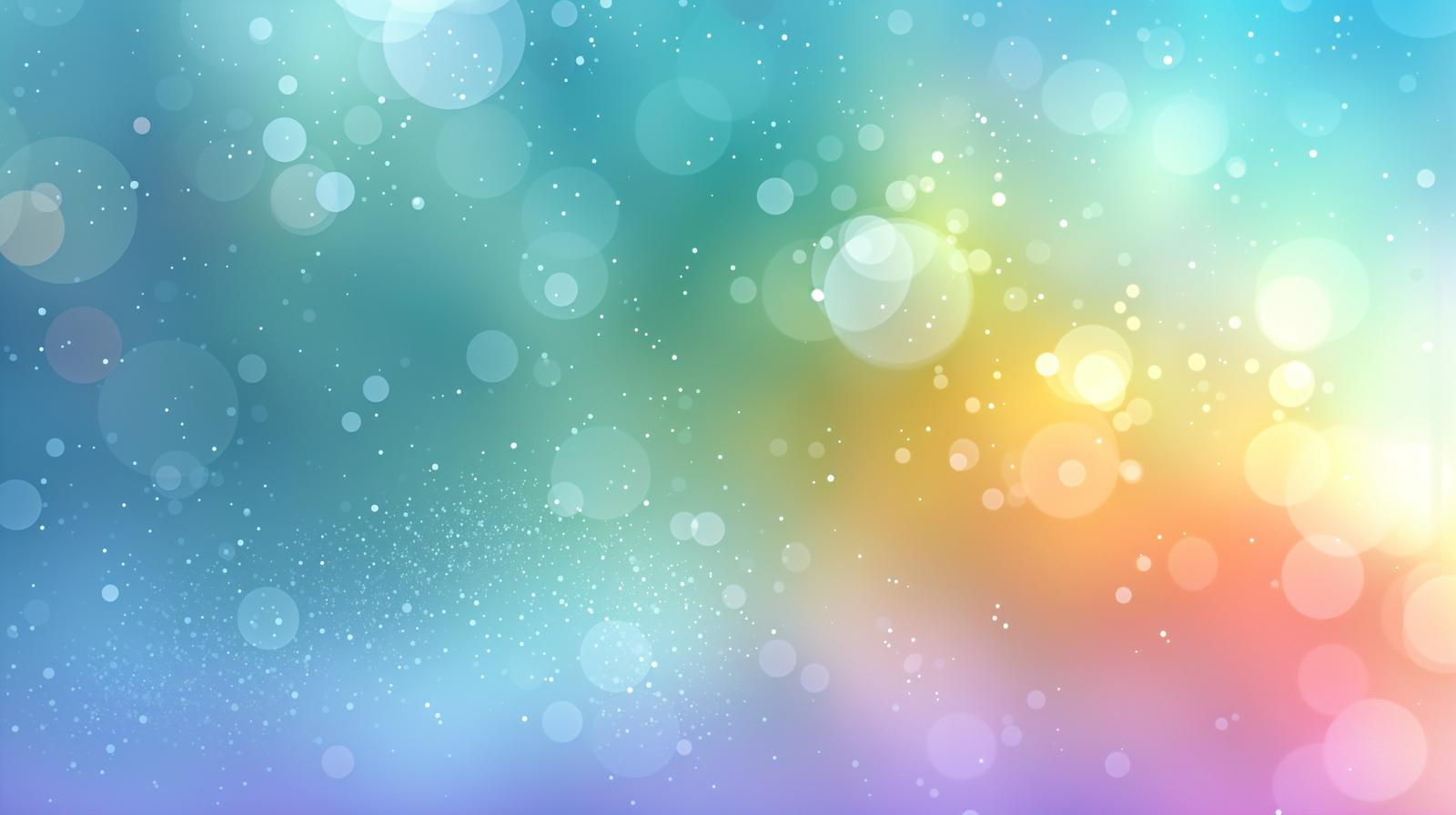 虹色のグラデーション背景に大小の光粒子と玉ボケが舞う