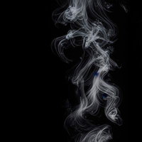 黒背景に立ち上がる白いスモークの静寂な抽象美の写真
