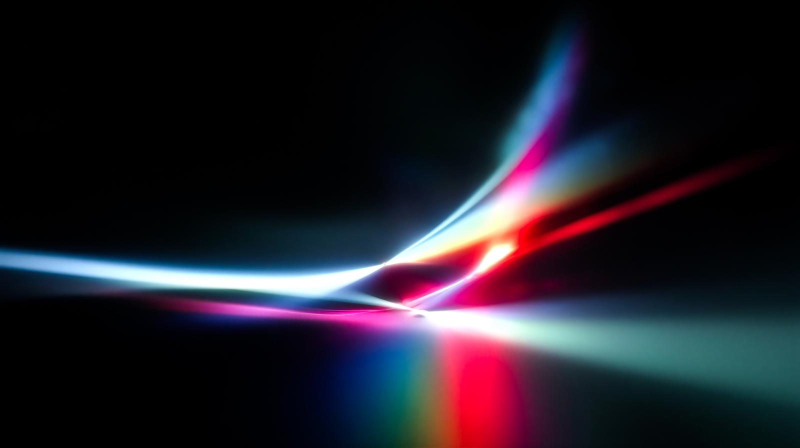 黒い背景に青と赤の光線が中央で交差し放射状に広がるCG画像