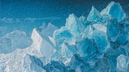 青く透明な氷塊が重なり合う氷山の表面