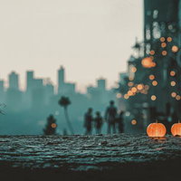 夕暮れの都市背景に光るハロウィンかぼちゃランタンの写真