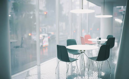 スタイリッシュな椅子と丸テーブルが並ぶ静かなカフェ空間