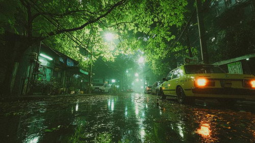 雨上がりの静かな夜道に灯るタクシーのテールランプ