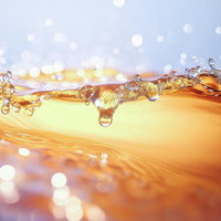 注ぎたてのビールのような黄金の飛沫と泡立つ水面の写真