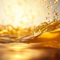 蜂蜜のような琥珀色の液体から落ちる一滴と無数の気泡の写真