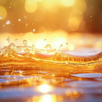 甘美なとろみと透明感のある黄金色に輝く蜂蜜の水飛沫の写真