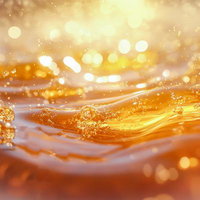 光を反射して広がるはちみつの水飛沫と液体波紋の写真