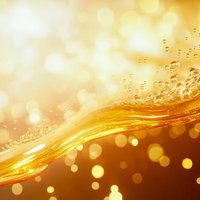 琥珀色に輝く気泡がはじける美容液風の液体の写真