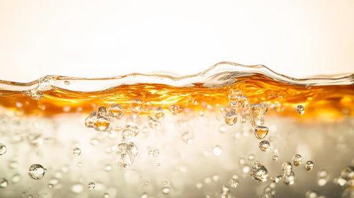 黄金色の液体に舞い上がる透明な気泡と水面の波紋