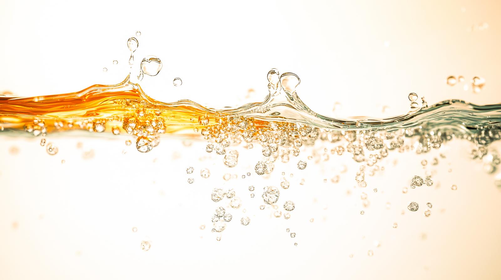 黄金色の液体に浮かぶ無数の気泡と水滴