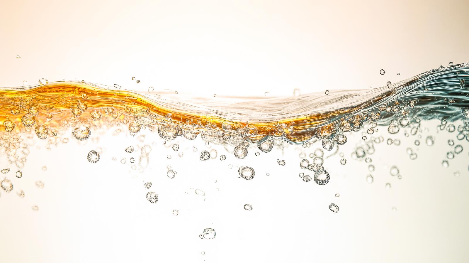 波打つ水面に無数の気泡が浮かぶ液体の表面