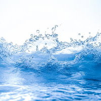 爽快感溢れる青い波しぶきと水飛沫、打ち寄せる波の躍動感の写真